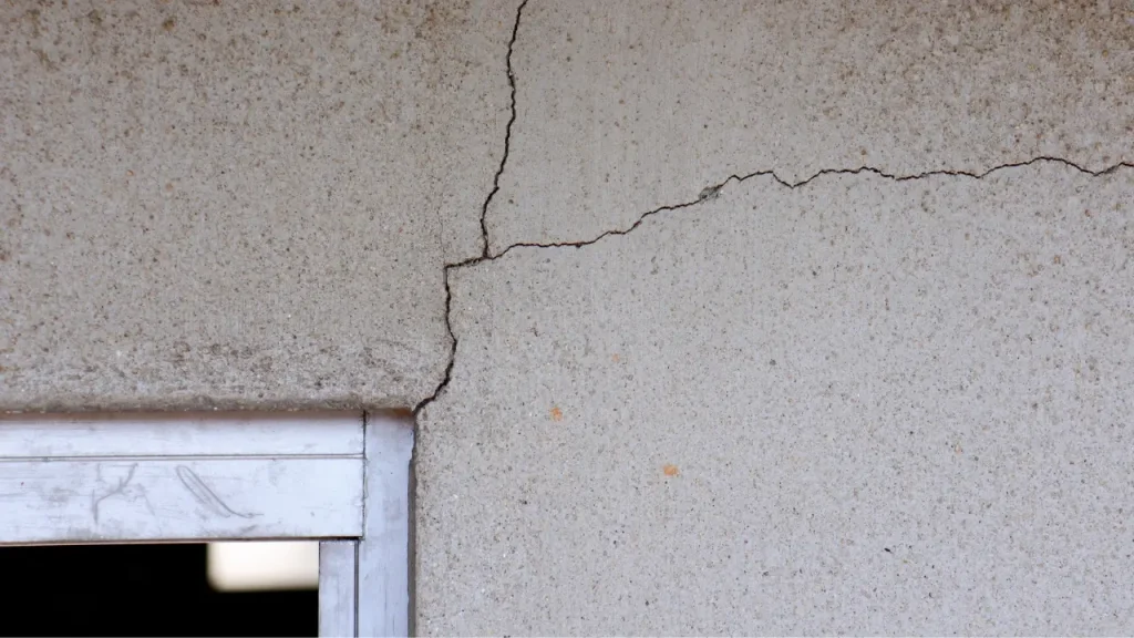 sprucken putsfasad runt fönster